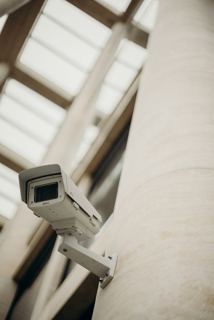 Close-up of a security camera on a building wall, showcasing surveillance technology.